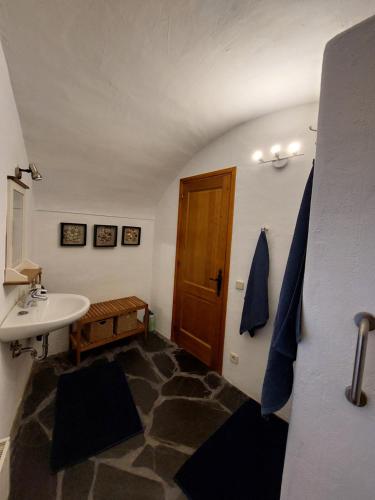 a bathroom with a sink and a wooden door at Cala Clareta in Castellfollit de la Roca