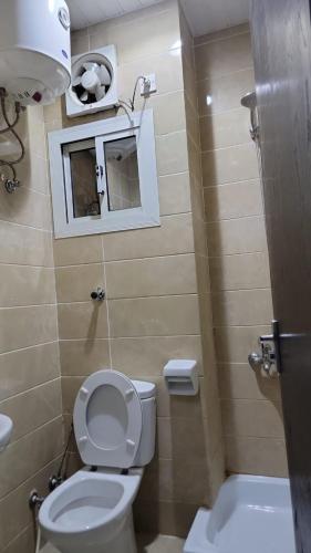 a small bathroom with a toilet and a window at منازل المنال in Makkah