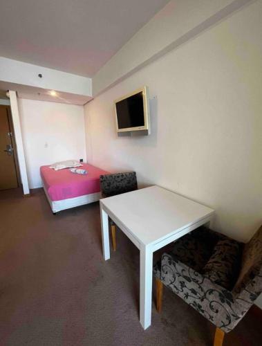 um pequeno quarto com uma mesa e uma cama em FLAT EM ALPHAVILLE HOTEL MELHOR LOCALIZAÇÃo em Barueri
