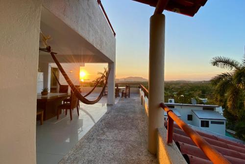 a balcony of a house with a view of the sunset at Vistas a las Montañas y al Mar I Condominio Las Calandrias I Alberca I Wi-Fi in Ixtapa