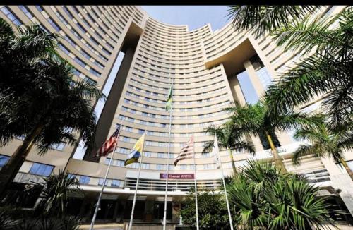 巴魯埃里的住宿－FLAT EM ALPHAVILLE HOTEL MELHOR LOCALIZAÇÃo，一座棕榈树环绕的大建筑