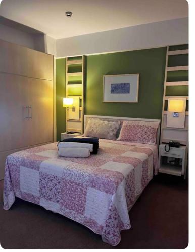um quarto com 2 camas e paredes verdes em FLAT EM ALPHAVILLE HOTEL MELHOR LOCALIZAÇÃo em Barueri