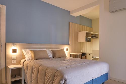 1 dormitorio con 1 cama grande y 2 mesas en Al Bacino Rooms And Breakfast, en Porto Viro