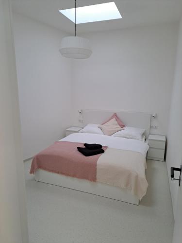 una camera bianca con letto e luce a ciondolo di Matea a Břeclav