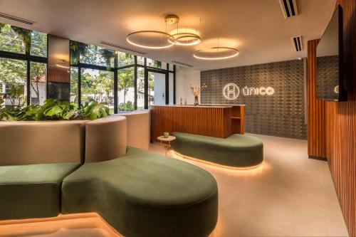 a waiting room with green ottomans in front of a waiting roomastery at ÚNICO - Stay & Residences by AVA in Asuncion
