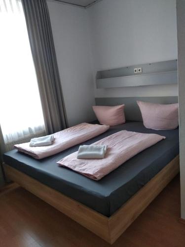two beds in a room with pink pillows on them at Pension Sonnenschein in Halle an der Saale