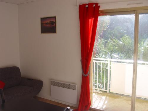 sala de estar con sofá y ventana en T2 bis Capvern les Bains proximité Lannemezan, en Capvern