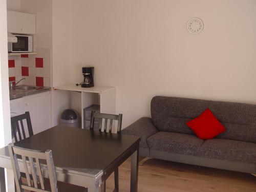 sala de estar con sofá y mesa con almohada roja en T2 bis Capvern les Bains proximité Lannemezan, en Capvern