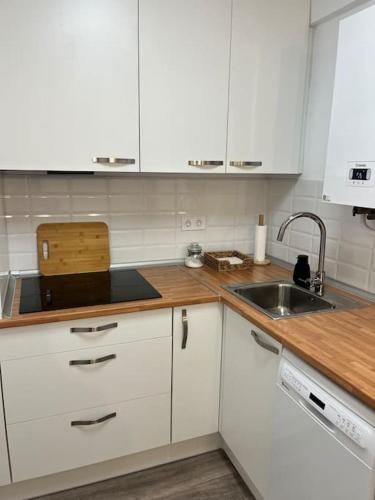 a kitchen with white cabinets and a sink at Piso recién reformado en el centro de Santander, zona estaciones in Santander