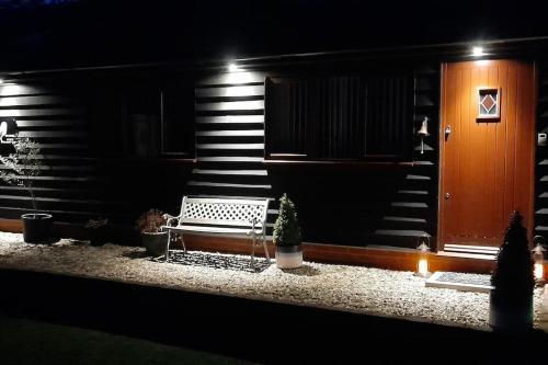 a house with a bench and a staircase at night at Owlhoot Annexe in Sudbury