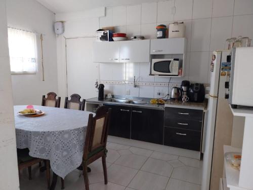 una pequeña cocina con mesa y nevera en Casa da Totonha en São Lourenço do Sul
