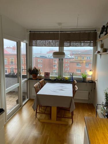 a dining room with a table and a large window at Guestroom in central Malmö in Malmö