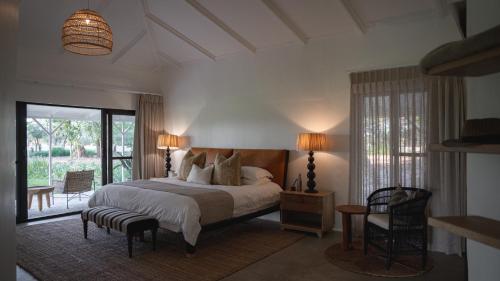a bedroom with a large bed and a balcony at Kolokolo Safari Home in Lentswelemoriti