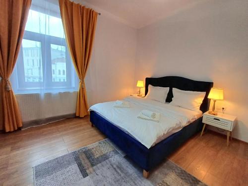 a bedroom with a bed and a large window at Bella Casa - ApartHotel in Dej