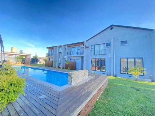 a house with a swimming pool in front of a house at Luxurious Mangethe Suite - 2206 in Bulawayo