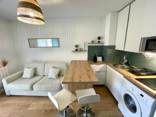 une cuisine et un salon avec une table et un canapé dans l'établissement Maria - Studio 4 personnes La Grande Motte (couchant), à La Grande Motte
