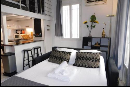 昂蒂布的住宿－Beau T1 bis centre Juan les pins，一间带白色床的卧室和一间厨房