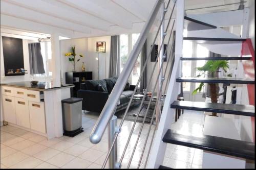 un salon avec un escalier menant à un salon dans l'établissement Beau T1 bis centre Juan les pins, à Antibes