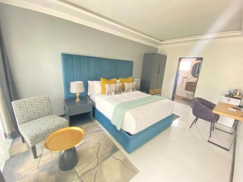 a bedroom with a king sized bed and a chair at Stunning Lotshe suite - 2207 in Bulawayo