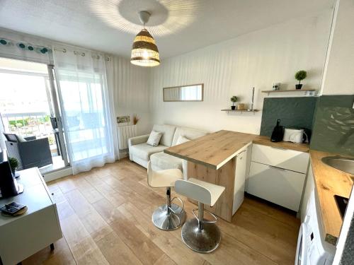 une cuisine et un salon avec une table et un canapé dans l'établissement Maria - Studio 4 personnes La Grande Motte (couchant), à La Grande Motte
