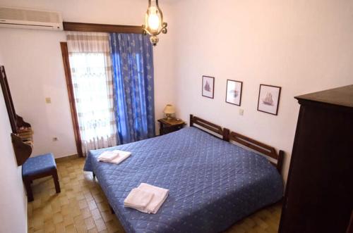 a bedroom with a blue bed with two towels on it at Elia Apartments Sithonia in Elia