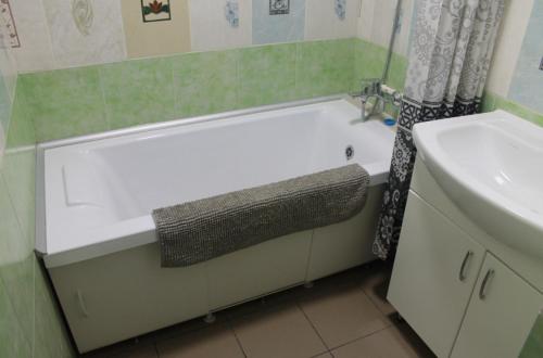 a bathroom with a white bath tub next to a sink at House in downtown in Bălţi