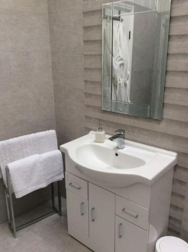 Baño blanco con lavabo y espejo en 2 bedroom apartment, great location for tourists, en Liverpool