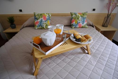 een dienblad met eten en sinaasappelsap op een bed bij Hotel Milano in Tolentino