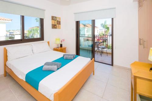 a bedroom with a large bed and a balcony at Villa Maya - 4bed with Private Heated Pool in Paralimni