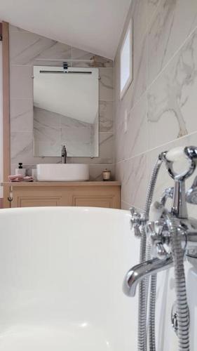 une salle de bain avec une baignoire et un lavabo dans l'établissement Le Quai, à Saint-Vincent-de-Cosse