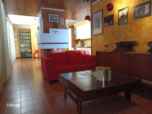 a living room with a red couch and a coffee table at Casa Riccio in Palermo