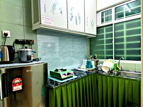 a kitchen with a counter with a sink and a stove at Izdisa Muslim Homestay For Muslim Groundfloor Pool view in Port Dickson