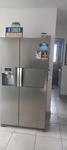 - un réfrigérateur en acier inoxydable dans une cuisine avec un panneau dans l'établissement Villa les Flamants roses, à Torreilles