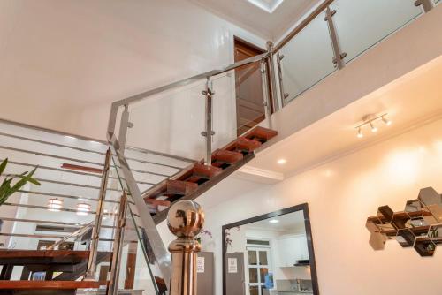 a metal staircase in a house with a mirror at Strata Homestay- Luxurious 2- Storey Townhouse in Baguio