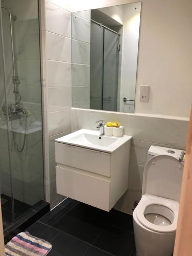 a bathroom with a toilet and a sink and a shower at Embasy Gardens by Rosy Apartments in Accra