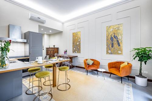a kitchen with orange chairs and a table at THREE APARTMENTS Via Roma in Florence