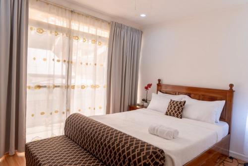 a bedroom with a large bed with a window at Strata Homestay- Luxurious 2- Storey Townhouse in Baguio