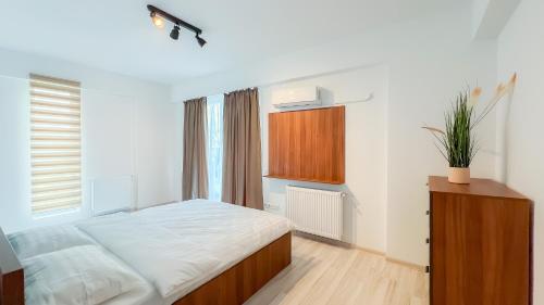 a bedroom with a large bed and a wooden cabinet at Como Life Inn in Bragadiru