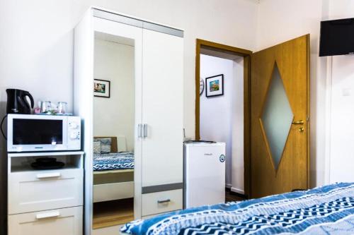 1 dormitorio con 1 cama y puerta con microondas en Cazare urbana, en Brasov
