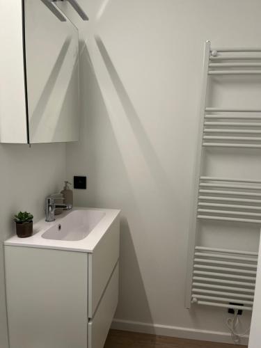 a white bathroom with a sink and a mirror at Studio-be in Nieuwpoort