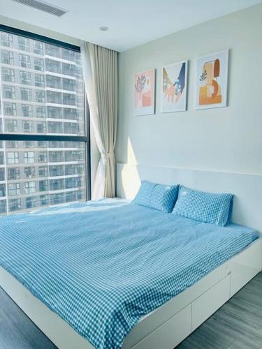 - une chambre avec un lit bleu et une fenêtre dans l'établissement Kim's homestay - Vinhomes OCean Park, à Gia Lâm Pho