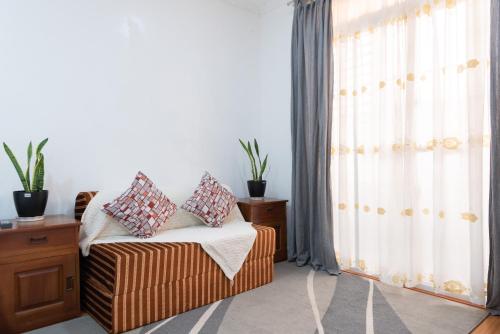 a bedroom with a bed and a window with curtains at Strata Homestay- Luxurious 2- Storey Townhouse in Baguio