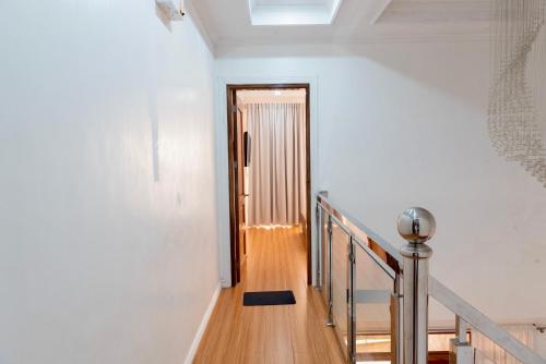 a hallway with white walls and a staircase with a door at Strata Homestay- Luxurious 2- Storey Townhouse in Baguio