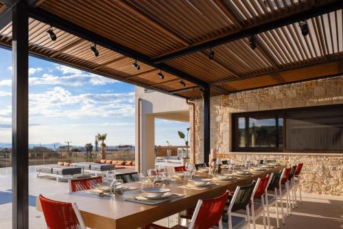 a dining room with a long table and chairs at Vellis Residence in Stavromenos