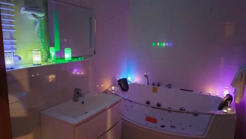 a bathroom with a tub and a sink with lights at Campoverde in Łódź