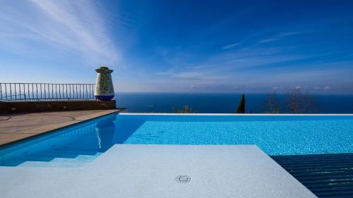 a swimming pool with a view of the ocean at Agriturismo Le Agavi in San Mauro Cilento