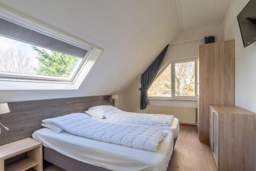 - 2 lits dans une chambre avec 2 fenêtres dans l'établissement Villapark Kamperfoelie 47, à De Koog