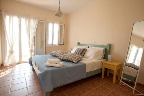 a bedroom with a bed with towels on it at Sun Blooming Villa in Tinos island in Agios Romanos