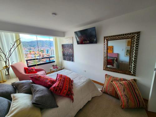 庫斯科的住宿－Apartamento de lujo en zona exclusiva de Cusco，一间卧室配有一张带镜子和椅子的床