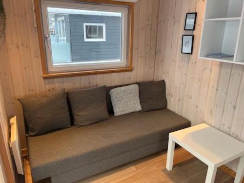 a couch in a room with a window and a table at Storebælt camping in Korsør